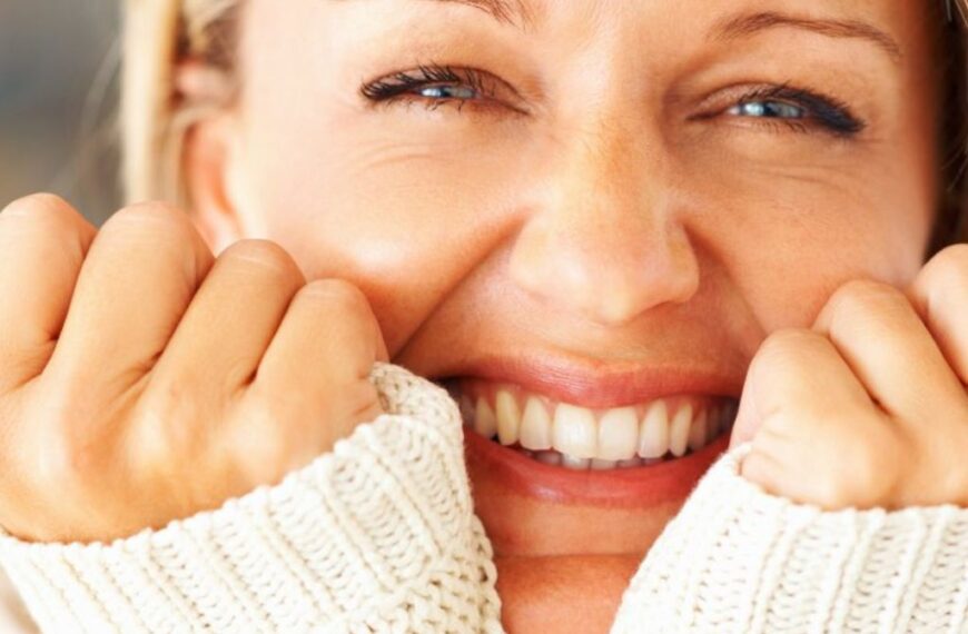 A close up of a smiling woman with bright healthy skin.